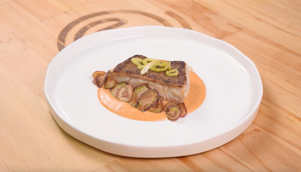 Pescado blanco sobre espejo de salsa romesco con pan